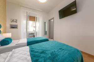 a bedroom with two beds and a flat screen tv at Preziosa in Pula