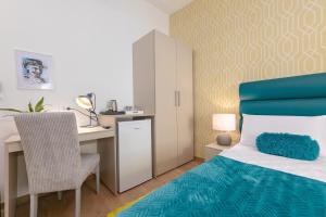 a bedroom with a desk and a bed with a blue bedspread at Preziosa in Pula