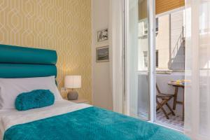 a bedroom with a bed with a blue headboard and a window at Preziosa in Pula