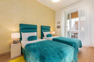 a bedroom with two beds with blue comforters at Preziosa in Pula