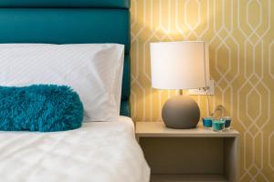 a bed with a blue pillow and a lamp on a night stand at Preziosa in Pula
