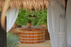 uma banheira de madeira num quarto com plantas e cortinas em Lavand'Ange et SPA em Sarrians