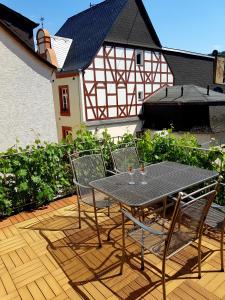una mesa y sillas en un patio con una casa en Gästehaus Kretschmann, en Zeltingen-Rachtig