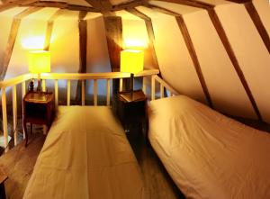 two beds in a room with two lamps at Le Moulin de la Motte Baudoin in Noyers-sur-Cher