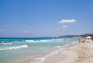 une plage avec beaucoup de gens dans l'eau dans l'établissement "Casa di Angelica" - un'oasi di pace a 300m dal mare, à Gallipoli