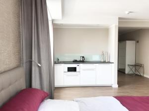 a bedroom with a bed and a kitchen at TH39 Trend Hotel in Bad Vilbel