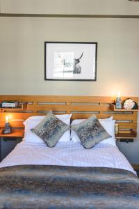 een slaapkamer met een groot bed met 2 kussens bij MONO Suites Old Town in Edinburgh