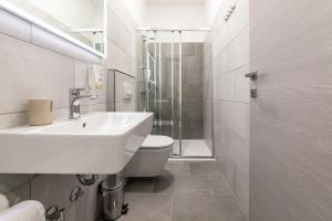 a bathroom with a sink and a toilet and a shower at Preziosa in Pula