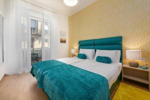a bedroom with a large bed with a blue headboard at Preziosa in Pula