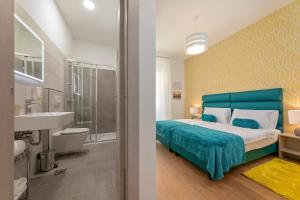a bedroom with a blue bed and a bathroom at Preziosa in Pula