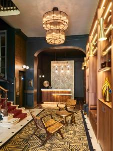 - un hall avec un lustre, une table et des chaises dans l'établissement Hotel Konti Bordeaux by HappyCulture, à Bordeaux