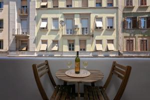 a table with a bottle of wine and two chairs at Preziosa in Pula