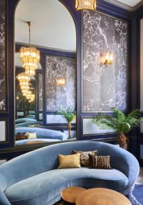 Habitación con 3 camas azules y sofá azul. en Hotel Konti Bordeaux by HappyCulture, en Burdeos
