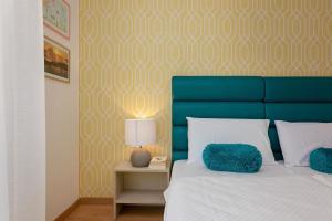 a bedroom with a bed with a blue head board at Preziosa in Pula