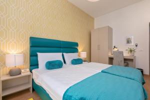 a bedroom with a large bed with blue pillows at Preziosa in Pula