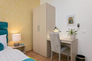 a bedroom with a desk and a bed and a cabinet at Preziosa in Pula