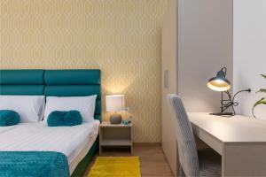 a bedroom with a blue headboard and a desk with a bed at Preziosa in Pula