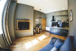 a living room with a blue couch and a kitchen at MONO Suites Old Town in Edinburgh