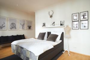 ein Schlafzimmer mit einem großen Bett und einigen Bildern an der Wand in der Unterkunft No1 Apartment Baden-Baden in Baden-Baden
