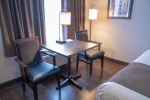 a room with a table, chairs and a lamp at Pocaterra Inn & Waterslide in Canmore