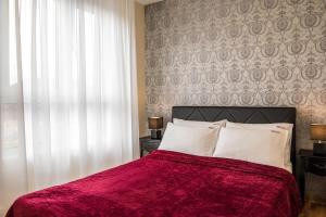 - une chambre avec un lit doté d'une couverture rouge et d'une fenêtre dans l'établissement SkyNet Apartments, à Zlatibor