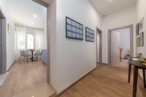 a hallway with white walls and a dining room with a table at Preziosa in Pula