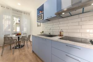 a white kitchen with a sink and a table at Preziosa in Pula