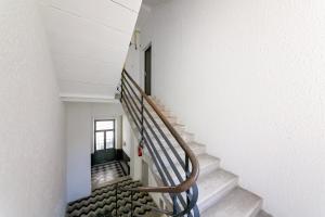 a winding staircase in a building with white walls at La Preziosa Rooms in Pula