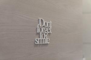 a metal sign that says dont forget to smile at La Preziosa Rooms in Pula