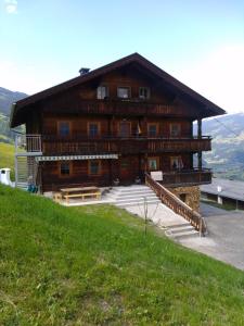 a large wooden building on top of a hill at Bauernhaus Fankhauser in Hippach