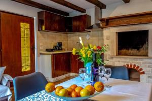a table with a bowl of fruit and a vase of flowers at Apartment Katia in Pula