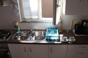 a kitchen sink with a blue tray on the counter at Apartment Katia in Pula +21 photos