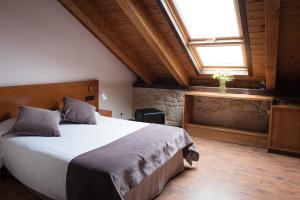 um quarto com uma cama grande e uma janela em Casa Rural Abadia Eiras em Rosal