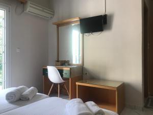 a bedroom with a desk and a bed and a chair at Naftilos Studios in Lourdata