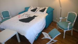 a bedroom with a bed with two chairs at WELCOME Bayeux in Bayeux +5 photos