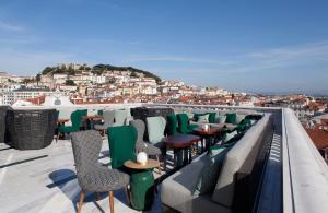 
a patio area with chairs, tables, and a balcony at Altis Avenida Hotel in Lisbon
