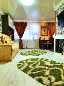 uma sala de estar com uma cama e um tapete verde em Apartment Ushakova 16 em Dnipro