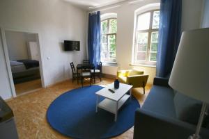 a living room with a couch and a blue rug at Nr9Marinehafen - Ferienwohnungen in Stralsund