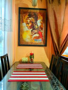 uma mesa de jantar com um quadro na parede em Apartment Ushakova 16 em Dnipro