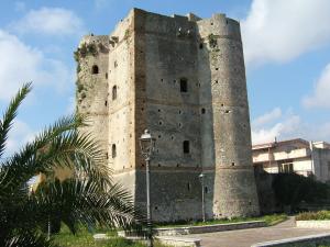 um velho castelo com uma luz de rua em frente em Holiday Home Marina em Marina di Gioiosa Ionica