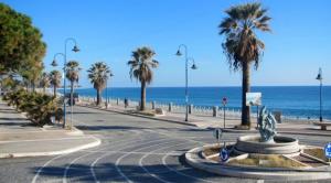 una calle vacía con palmeras y el océano en Holiday Home Marina, en Marina di Gioiosa Ionica
