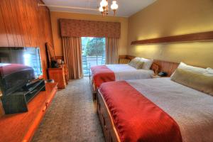 ein Hotelzimmer mit zwei Betten und einem Flachbildfernseher in der Unterkunft Gatlinburg Inn in Gatlinburg