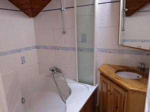 a bathroom with a tub and a sink at Agréable T3 mezzanine jusqu'à 5 personnes in Briançon