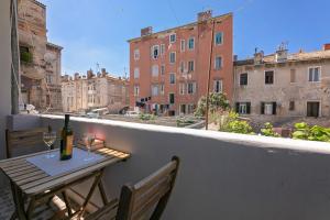 a table with a bottle of wine on a balcony at La Preziosa Rooms in Pula