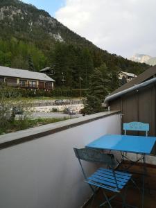 une table bleue et une chaise sur un balcon dans l'établissement Agréable T3 mezzanine jusqu'à 5 personnes, à Briançon