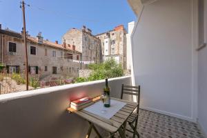 a small table with a bottle of wine on a balcony at La Preziosa Rooms in Pula