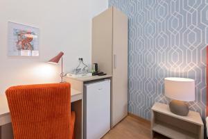 a room with a desk with a chair and a cabinet at La Preziosa Rooms in Pula