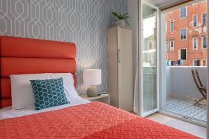 a bedroom with a bed with a red headboard and a window at La Preziosa Rooms in Pula