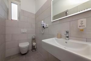 a bathroom with a sink and a toilet and a mirror at La Preziosa Rooms in Pula