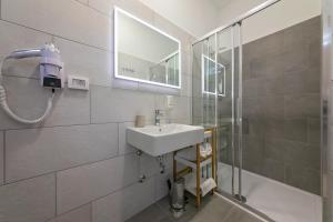 a bathroom with a sink and a shower at La Preziosa Rooms in Pula